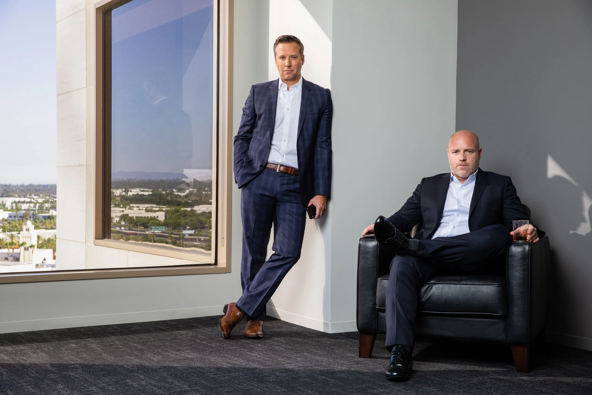 Portrait of Michael D. Mortenson and Craig A. Taggart in a bright office by a large window.